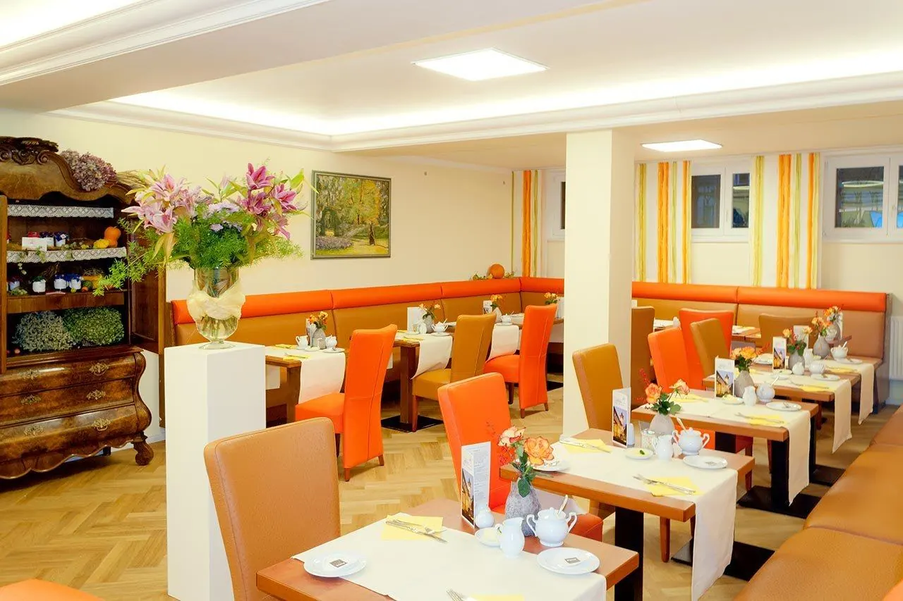 Lichter Frühstücksraum mit gedeckten Tischen