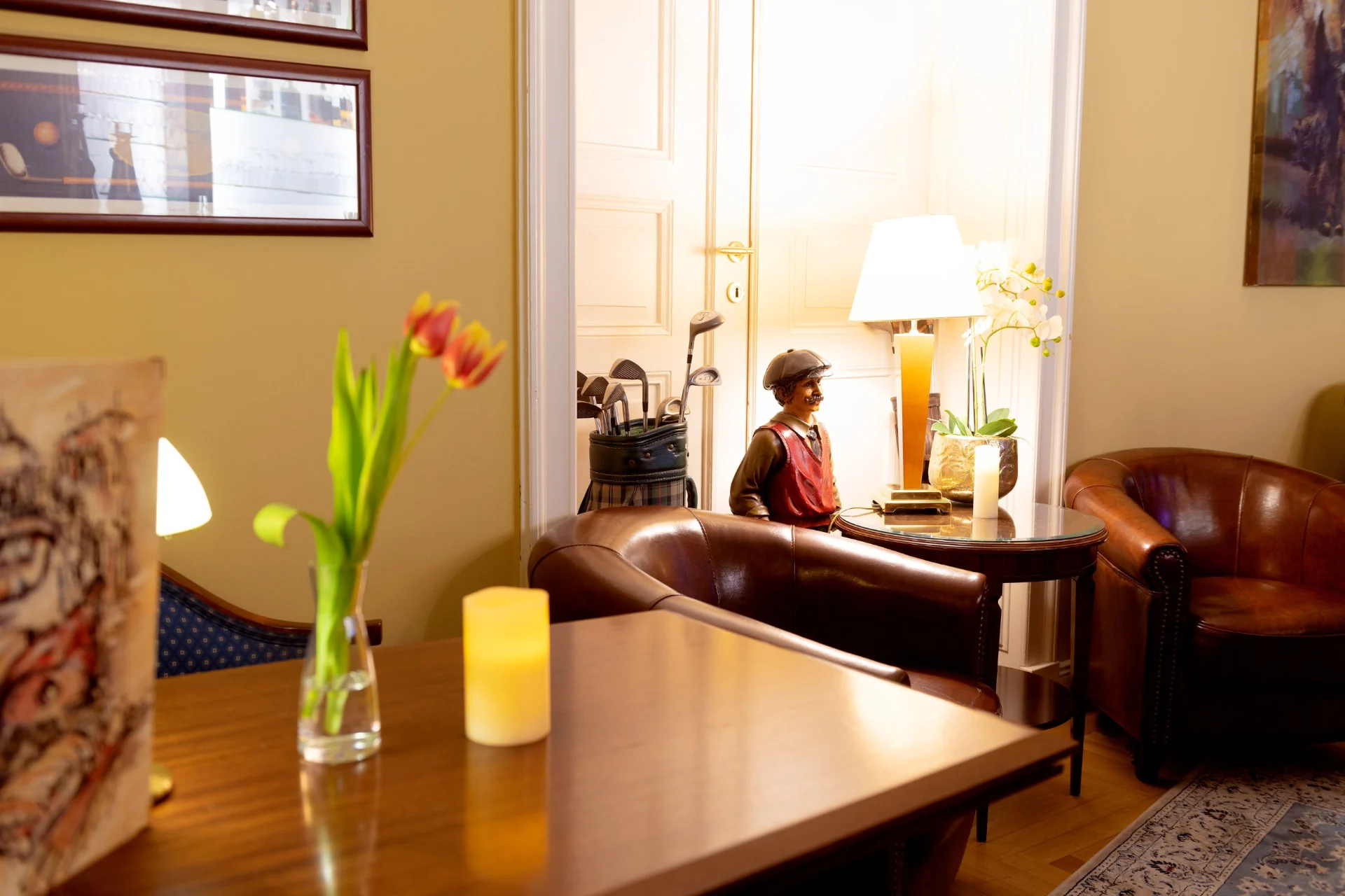 Gemütliche Sitzecke der Hotelbar mit Ledersesseln, Tulpen und warmem Licht