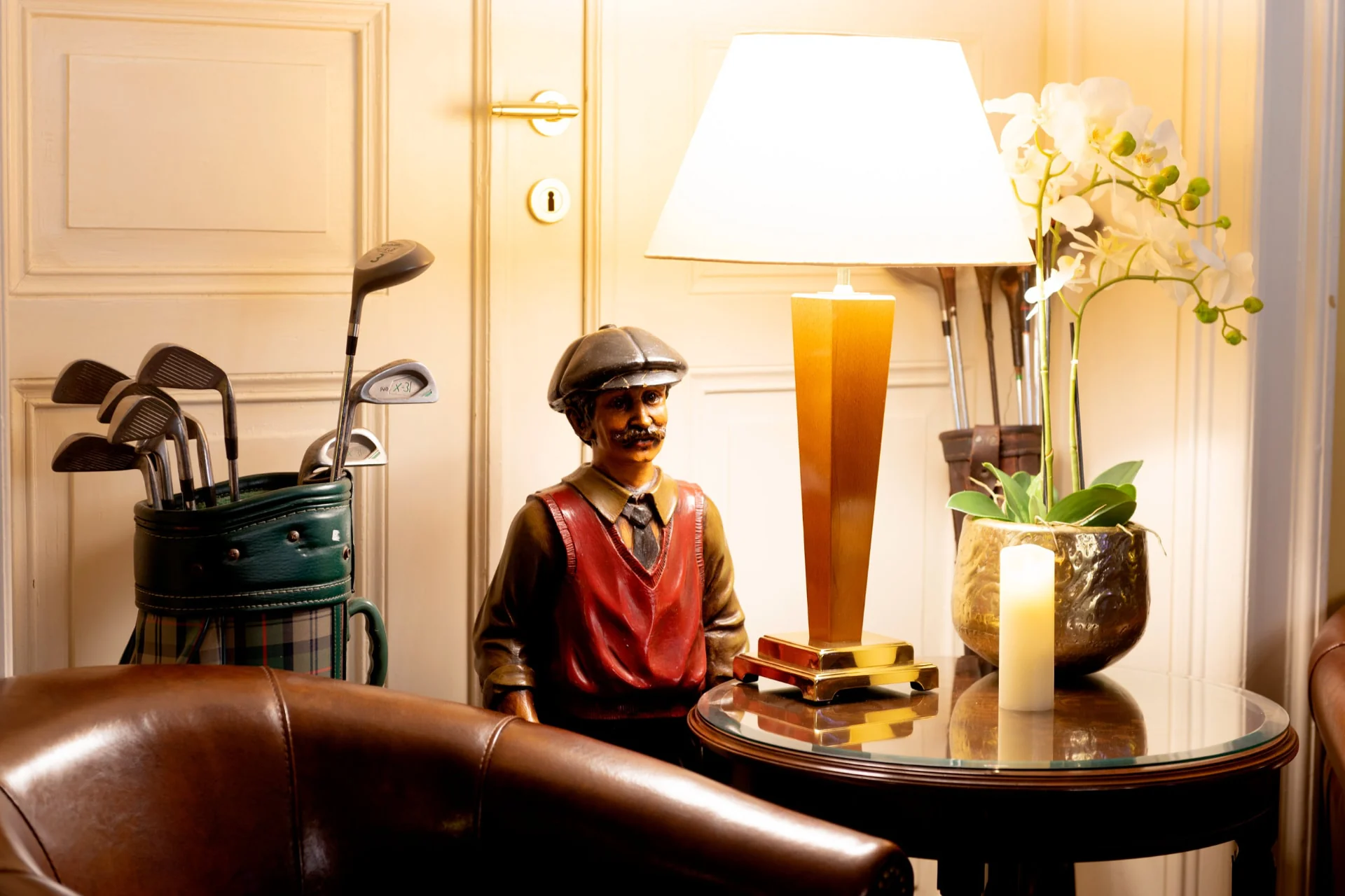 Golf-Dekoration mit Figur, Orchidee und Tischlampe in der Hotelbar