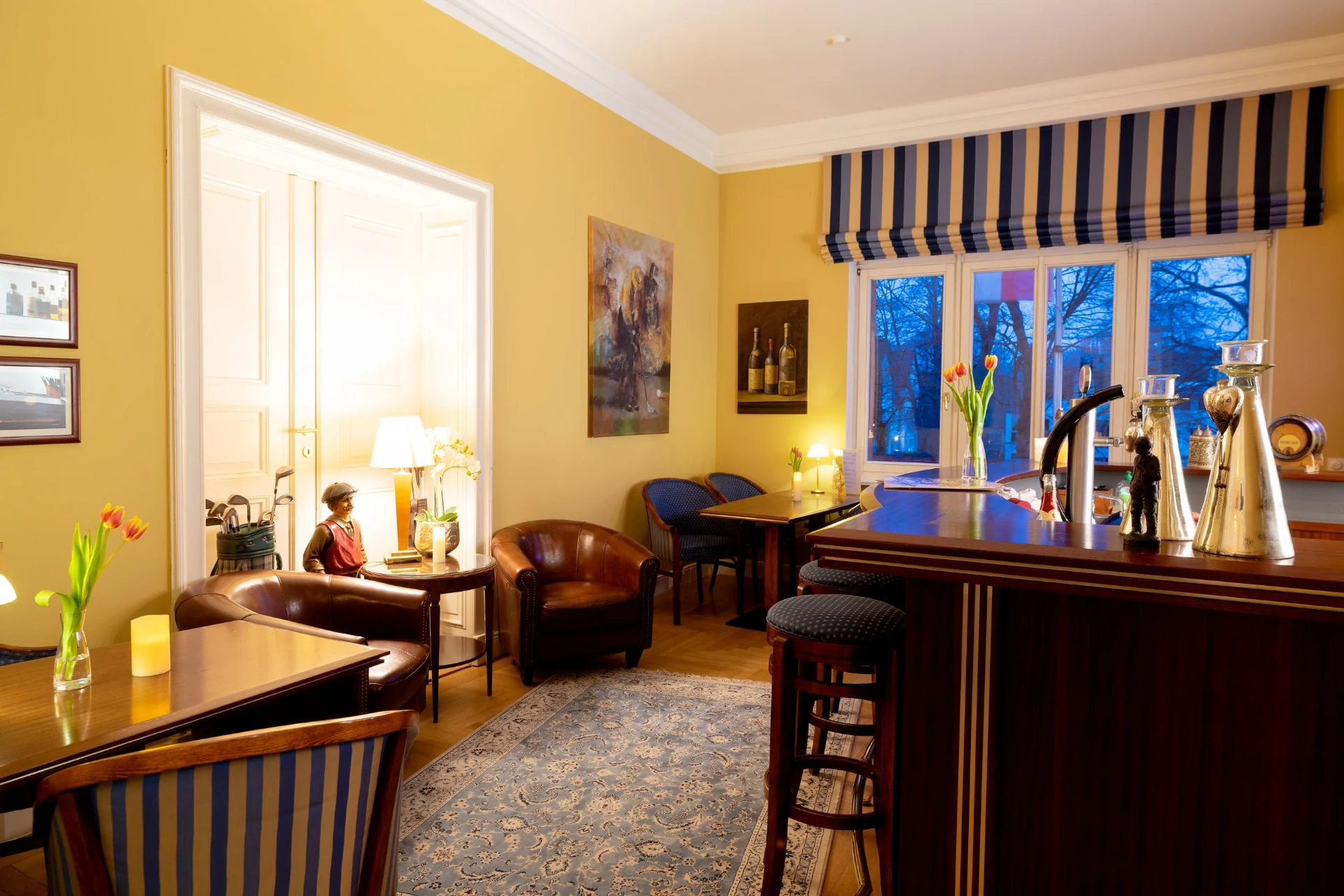 Hotelbar der Villa Monte Vino Potsdam mit Tresen, Ledersesseln und Blick in den Abend